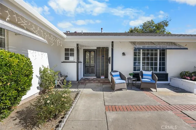 a view of a patio with couches table and chairs and potted plants