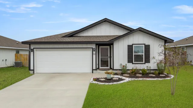 a front view of house with yard and garage