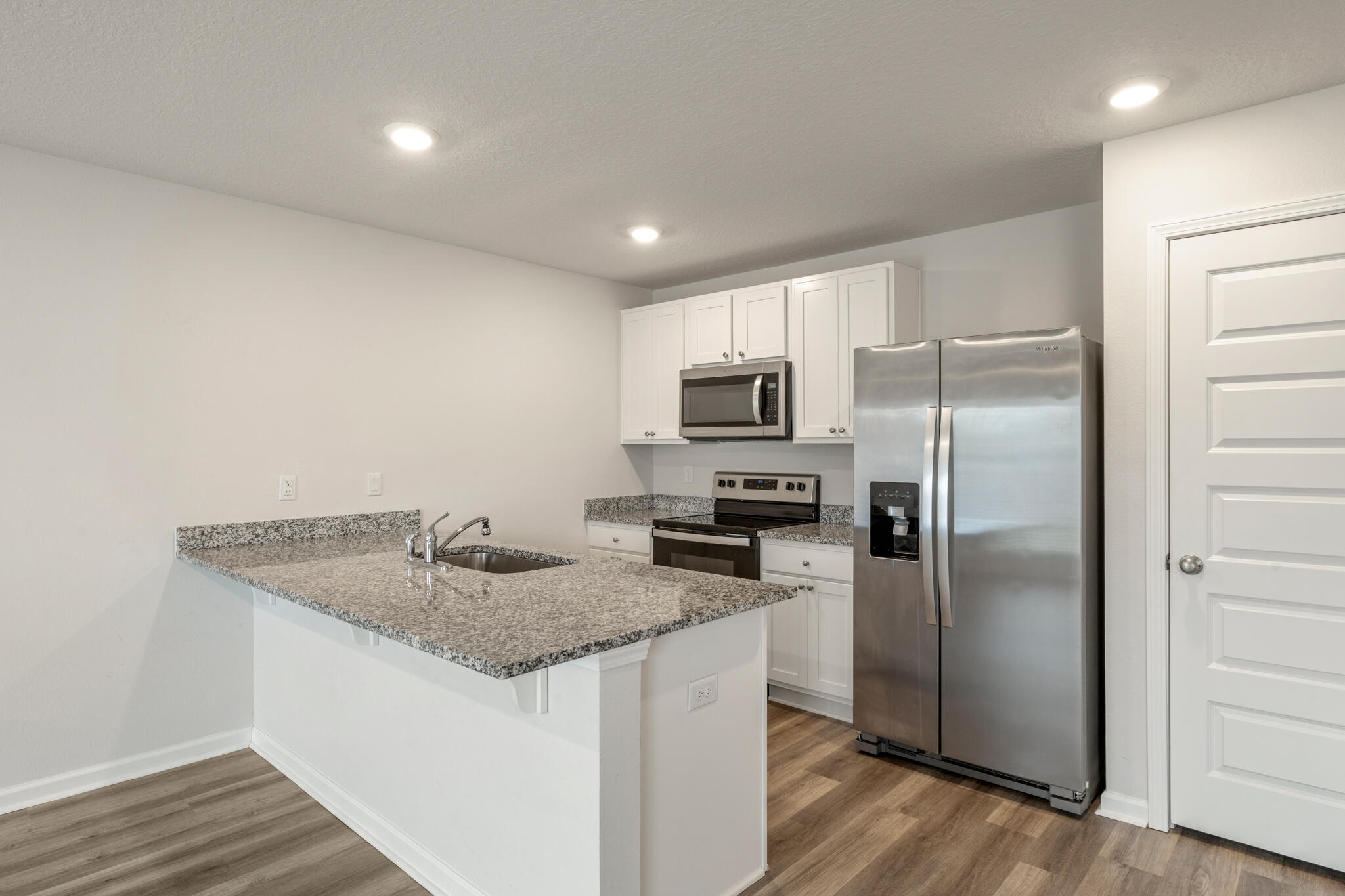 932 Sandbar Loop Crestview, FL 32539 - Photo 11 of 44 a kitchen with a refrigerator a microwave a sink and dishwasher with wooden floor