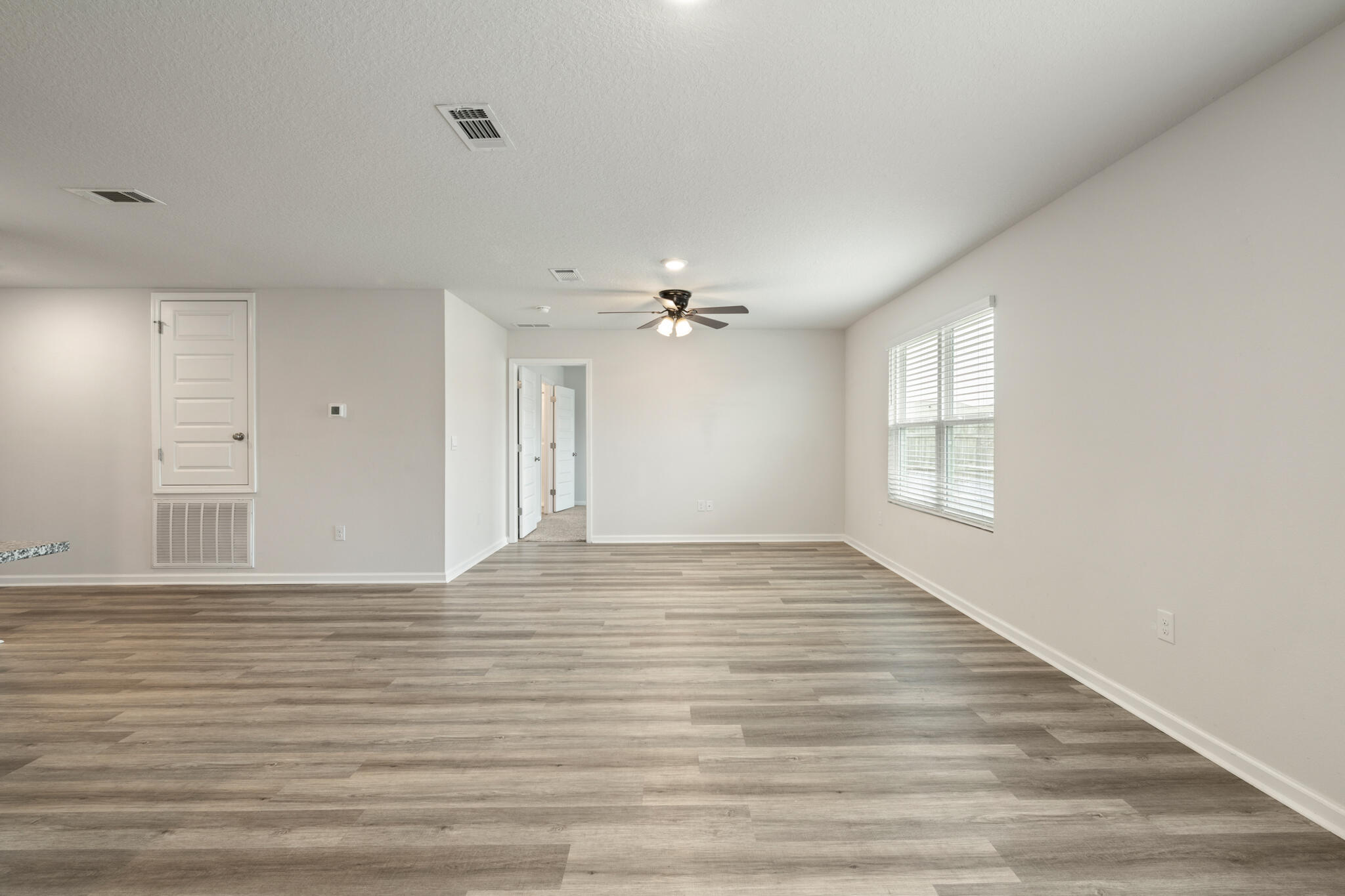 932 Sandbar Loop Crestview, FL 32539 - Photo 14 of 44 a view of an empty room with wooden floor and a window
