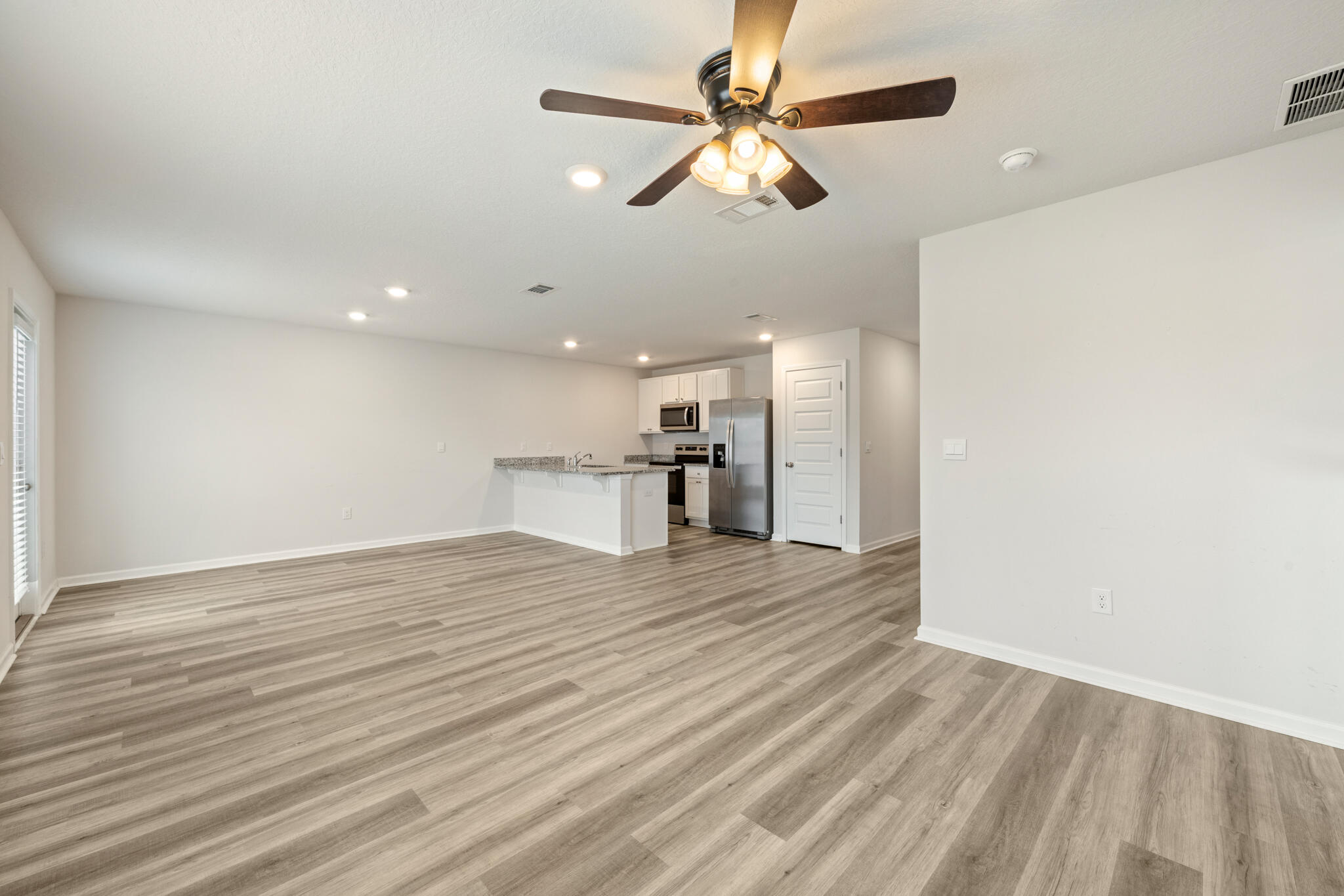 932 Sandbar Loop Crestview, FL 32539 - Photo 16 of 44 a view of an empty room with wooden floor and a ceiling fan
