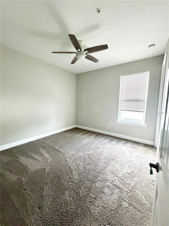 4606 West Fig Street, Unit 2 Tampa, FL 33609 - Photo 23 of 26 an empty room with a ceiling fan and a window