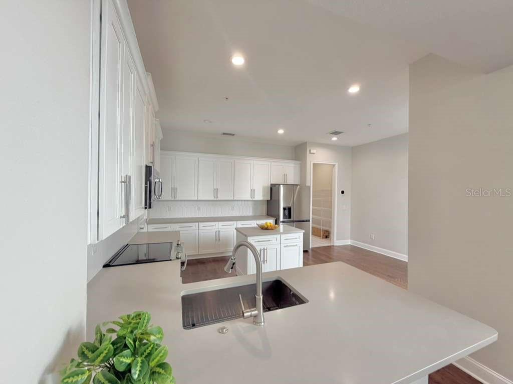 4606 West Fig Street, Unit 2 Tampa, FL 33609 - Photo 6 of 26 a living room with stainless steel appliances furniture a rug and a kitchen view