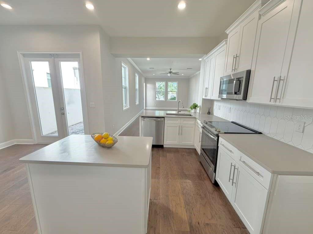 4606 West Fig Street, Unit 2 Tampa, FL 33609 - Photo 8 of 26 a kitchen with stainless steel appliances a stove a sink cabinets and a refrigerator
