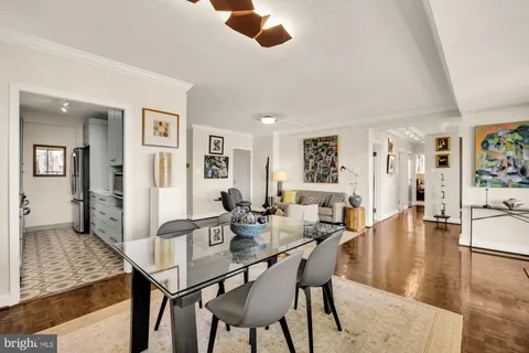 a view of a dining room and livingroom with furniture wooden floor a rug a fireplace and a painting