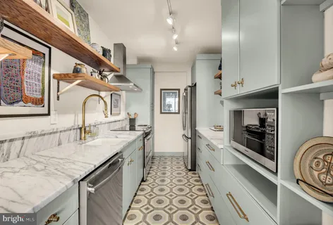 a large kitchen with stainless steel appliances granite countertop a sink and cabinets