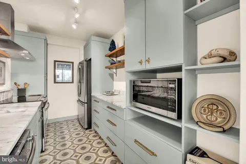 a kitchen with kitchen island granite countertop a stove and a sink