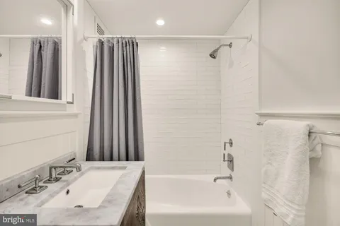a bathroom with a tub sink and a mirror