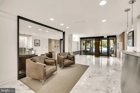 a living room with furniture and refrigerator