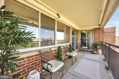 a balcony with furniture and a potted plant