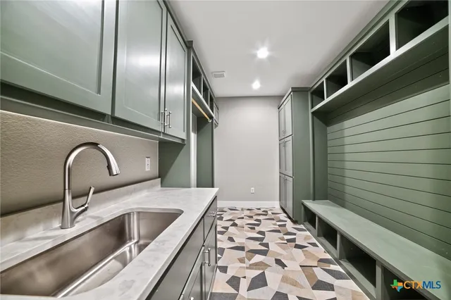 a kitchen with stainless steel appliances a sink a stove and cabinets