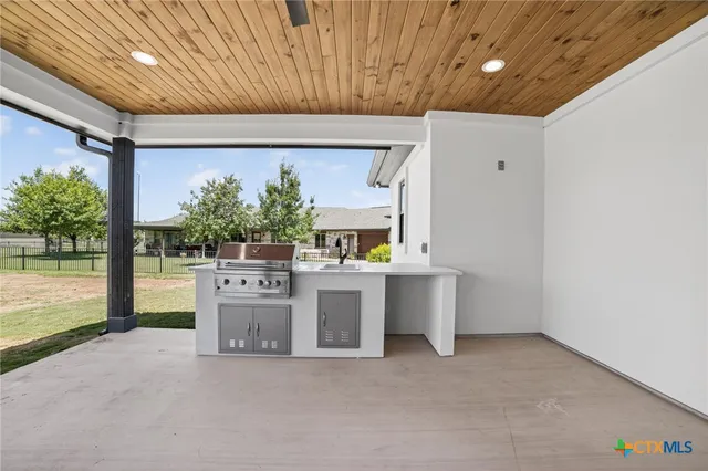 a view of an empty room with a sink and a large window