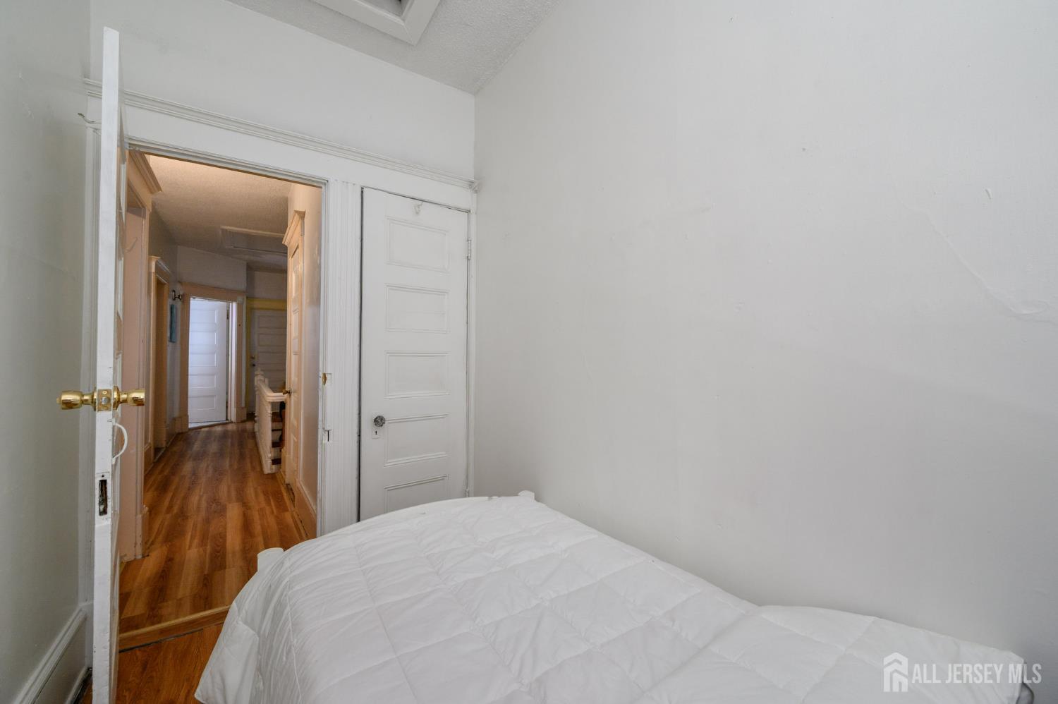 107 Market Street Perth Amboy, NJ 08861 - Photo 23 of 27 a bedroom with a bed and a mirror