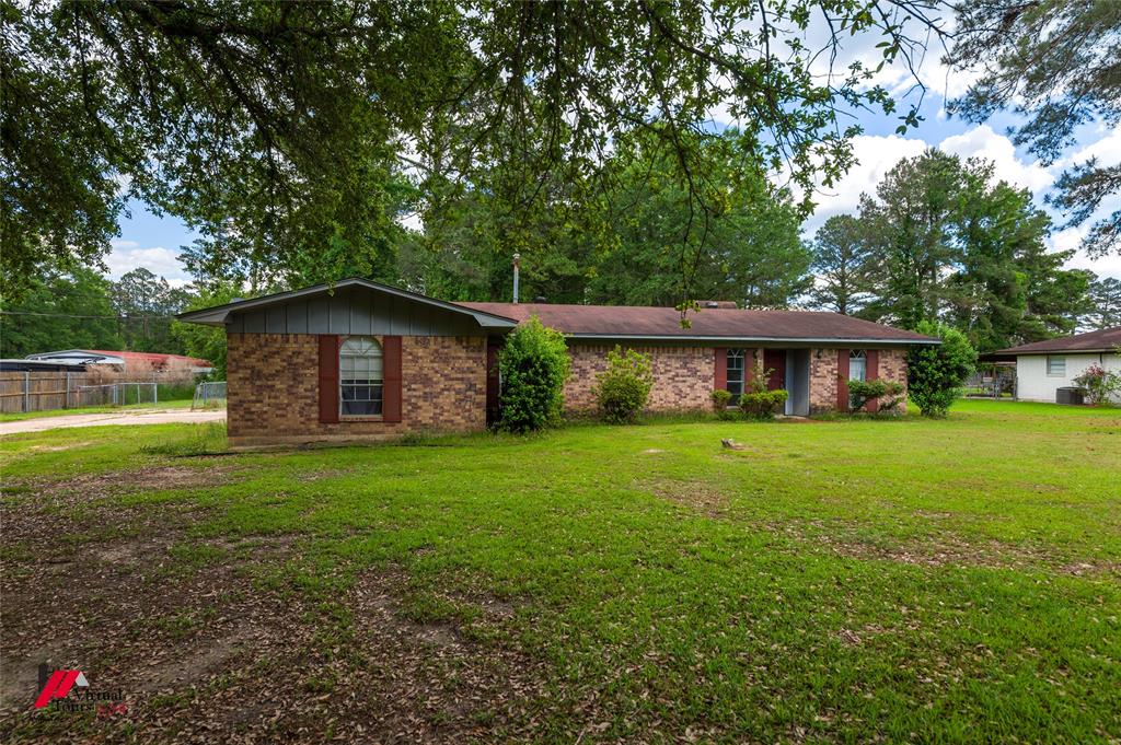 423 11th Street Northeast Springhill, LA 71075 - Photo 2 of 24 Brick exterior residence with a pitched roofline and an expansive front lawn