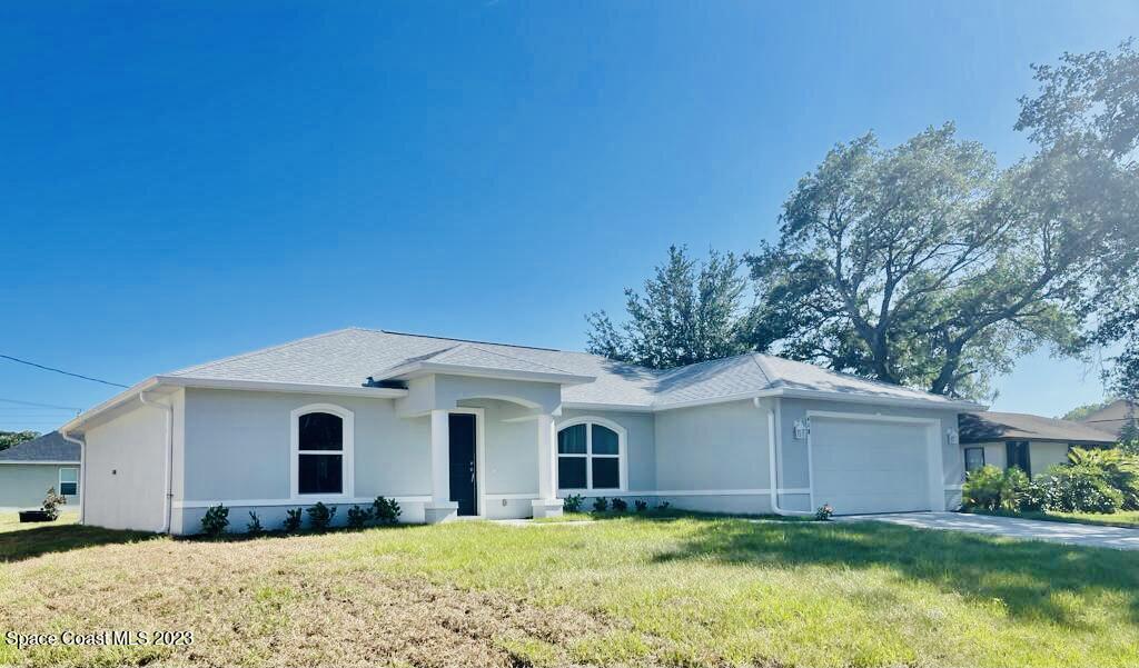 2351 Angel Road Palm Bay, FL 32909 - Photo 2 of 16 a front view of a house with a yard and garage