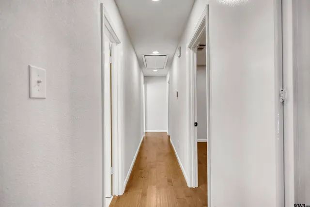 a view of a hallway with wooden floor