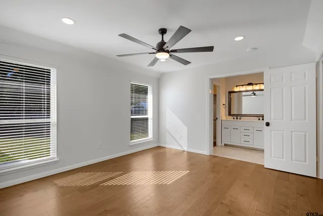 a view of a livingroom with a chandelier fan and windows