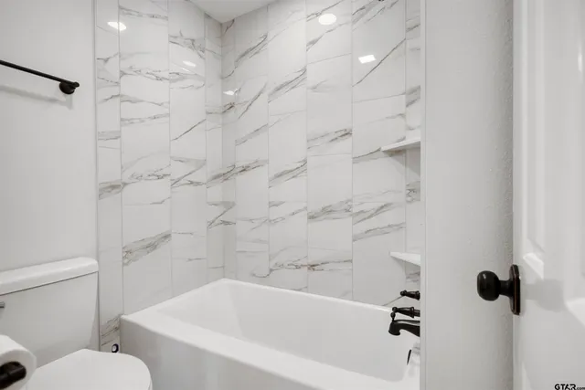 a white bath tub sitting next to a white toilet