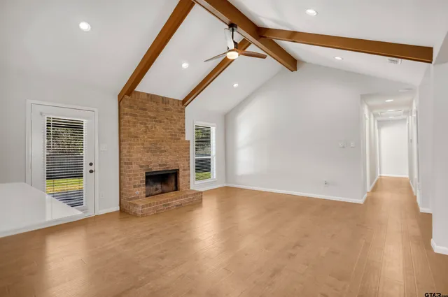 a view of an empty room with a fireplace and a window