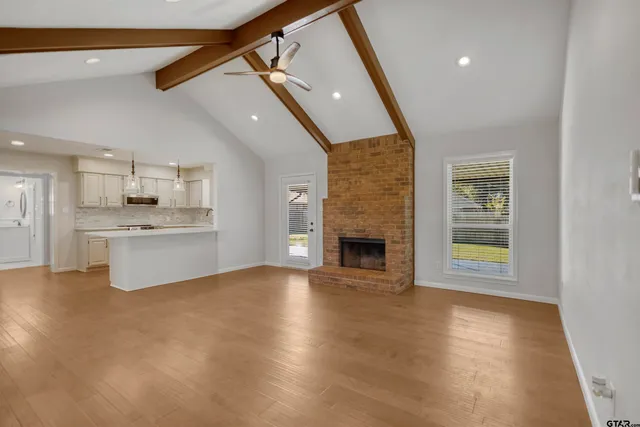 a view of an empty room with a fireplace and a window