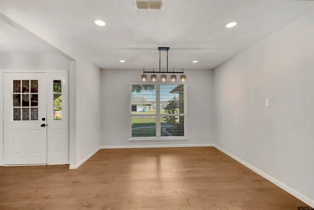 an empty room with windows and ceiling fan