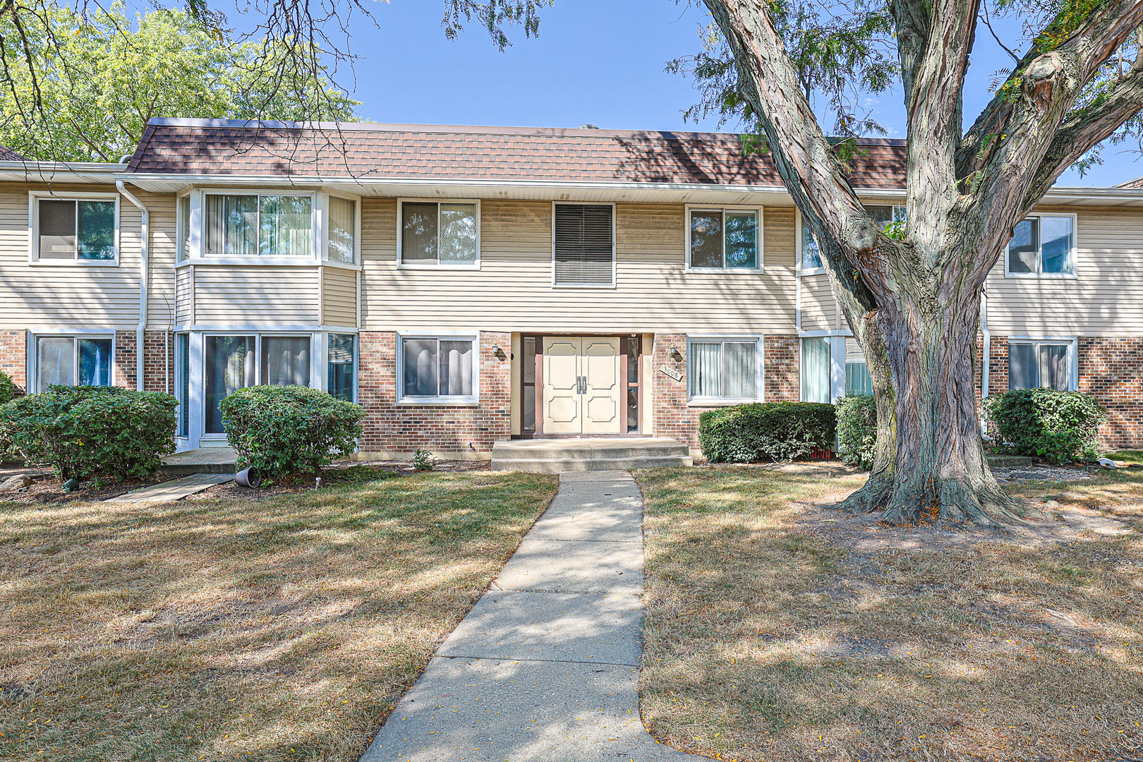 3008 Roberts Drive, Unit 5 Woodridge, IL 60517 - Photo 1 of 22 a front view of a house with a yard and potted plants