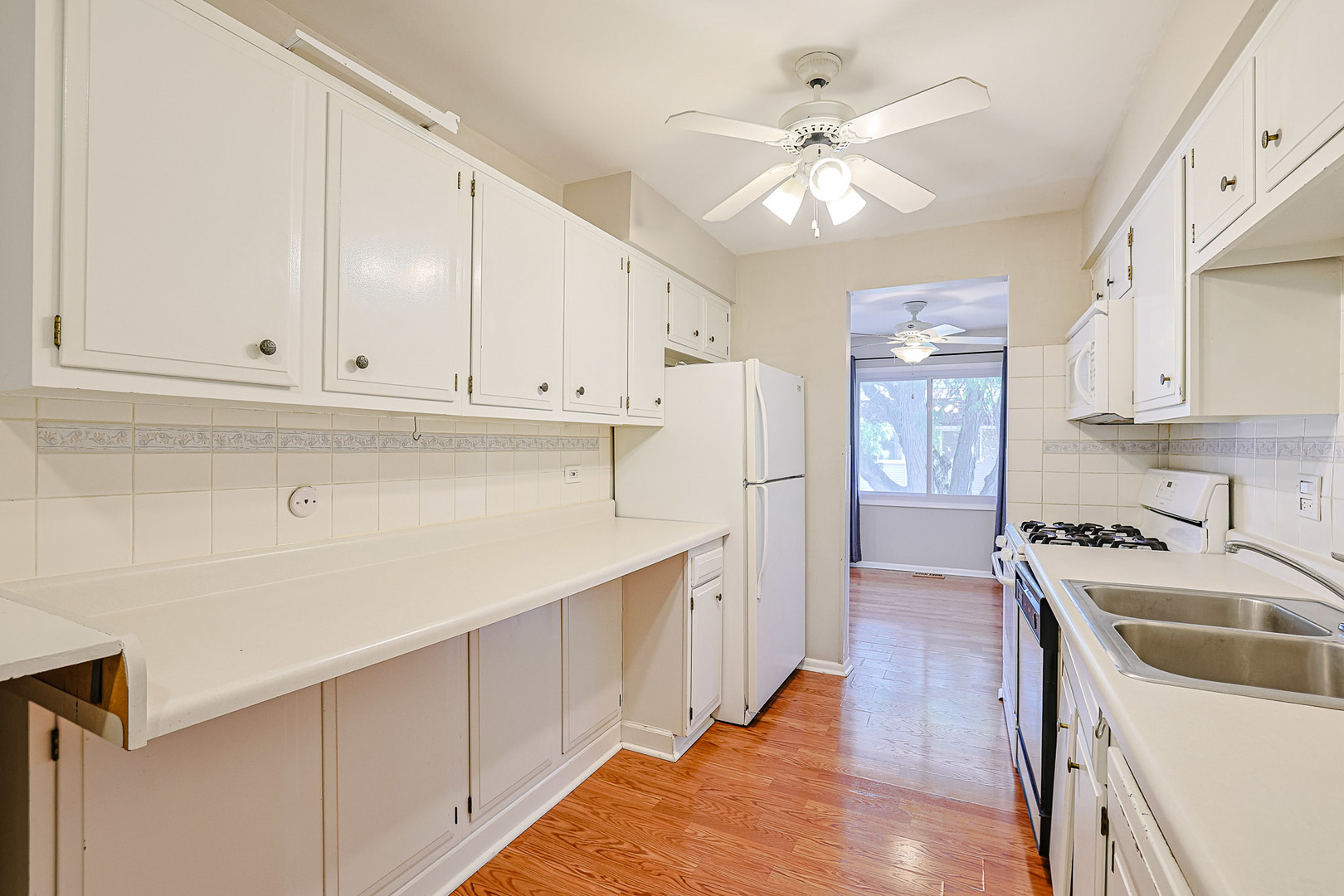 3008 Roberts Drive, Unit 5 Woodridge, IL 60517 - Photo 20 of 22 a kitchen with stainless steel appliances granite countertop a sink a stove a refrigerator and island with white cabinets