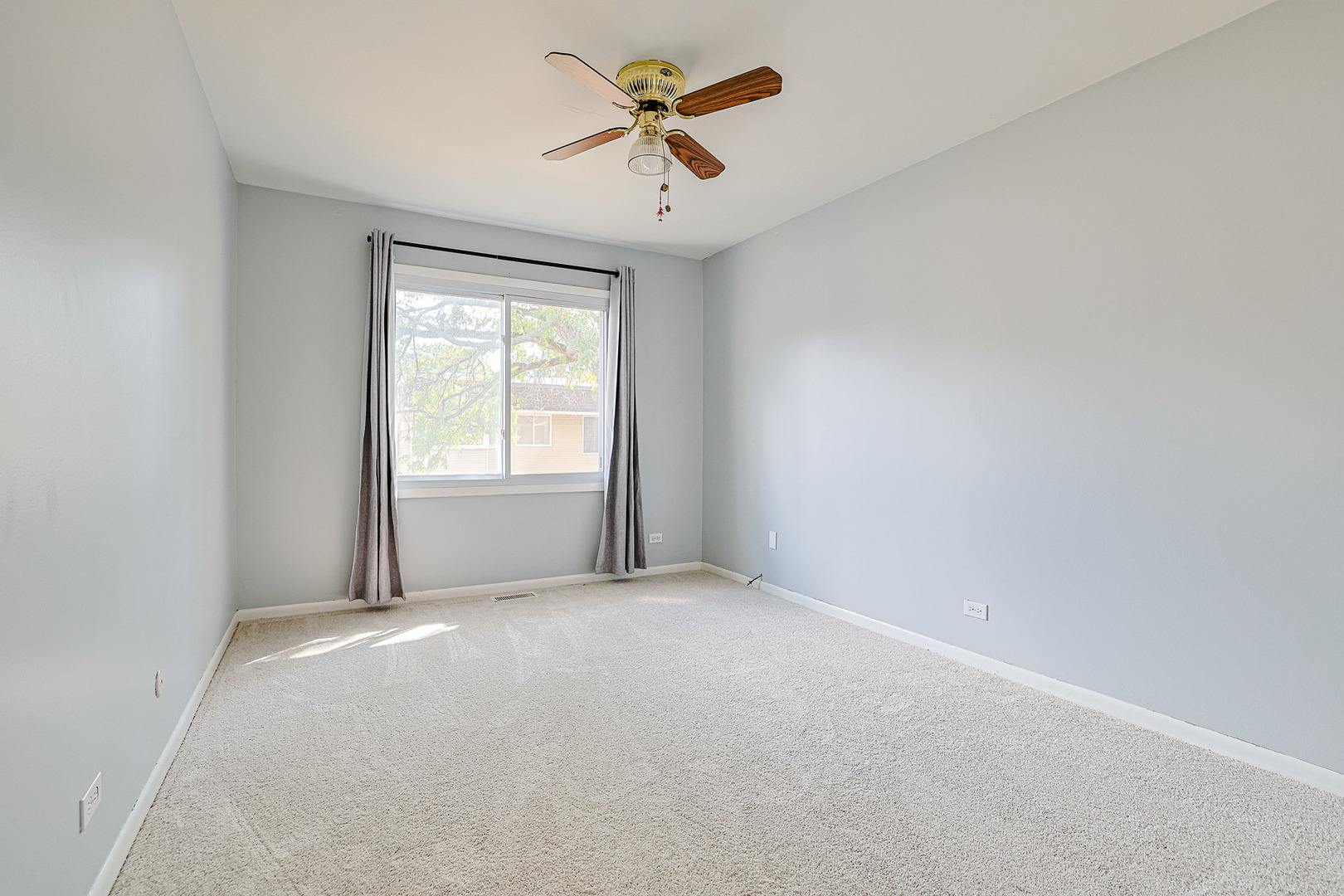 3008 Roberts Drive, Unit 5 Woodridge, IL 60517 - Photo 2 of 22 an empty room with windows and a ceiling fan