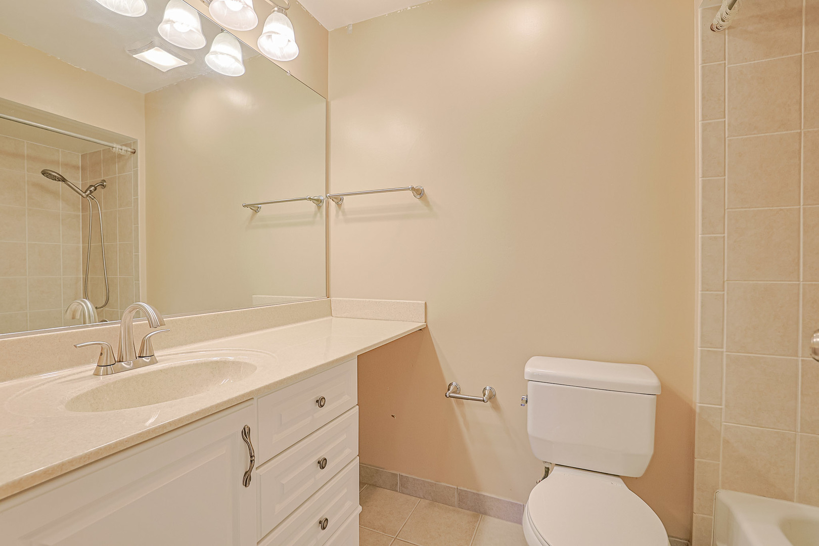 3008 Roberts Drive, Unit 5 Woodridge, IL 60517 - Photo 4 of 22 a bathroom with a toilet a sink and mirror