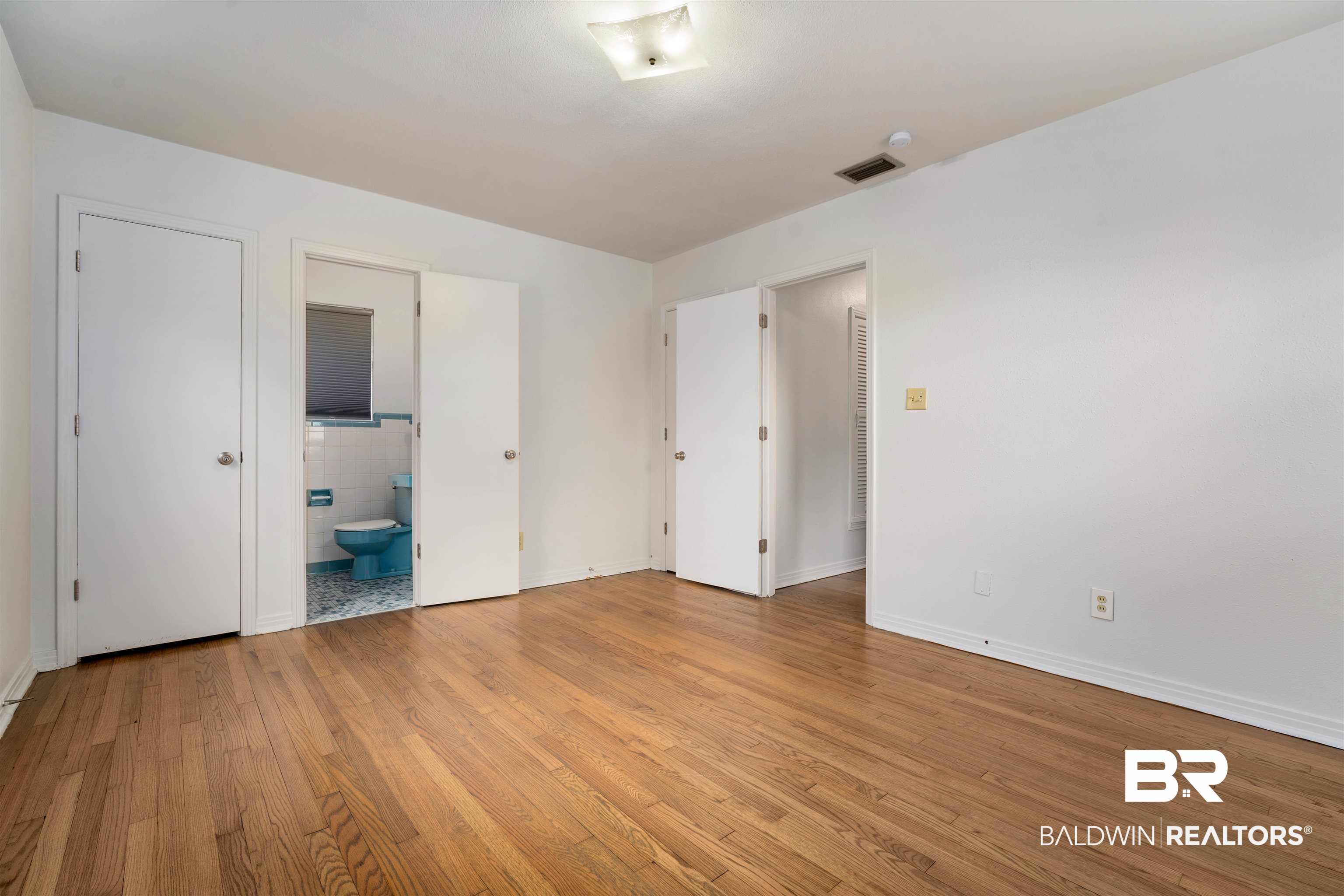 570 Markham Drive Mobile, AL 36609 - Photo 21 of 25 Unfurnished bedroom featuring ensuite bath, light wood-style flooring, visible vents, and baseboards