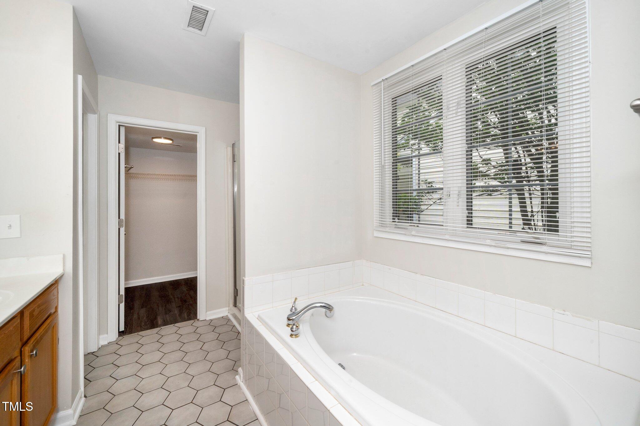 248 Inkster Cove Raleigh, NC 27603 - Photo 15 of 32 a bathroom with a bathtub and a shower