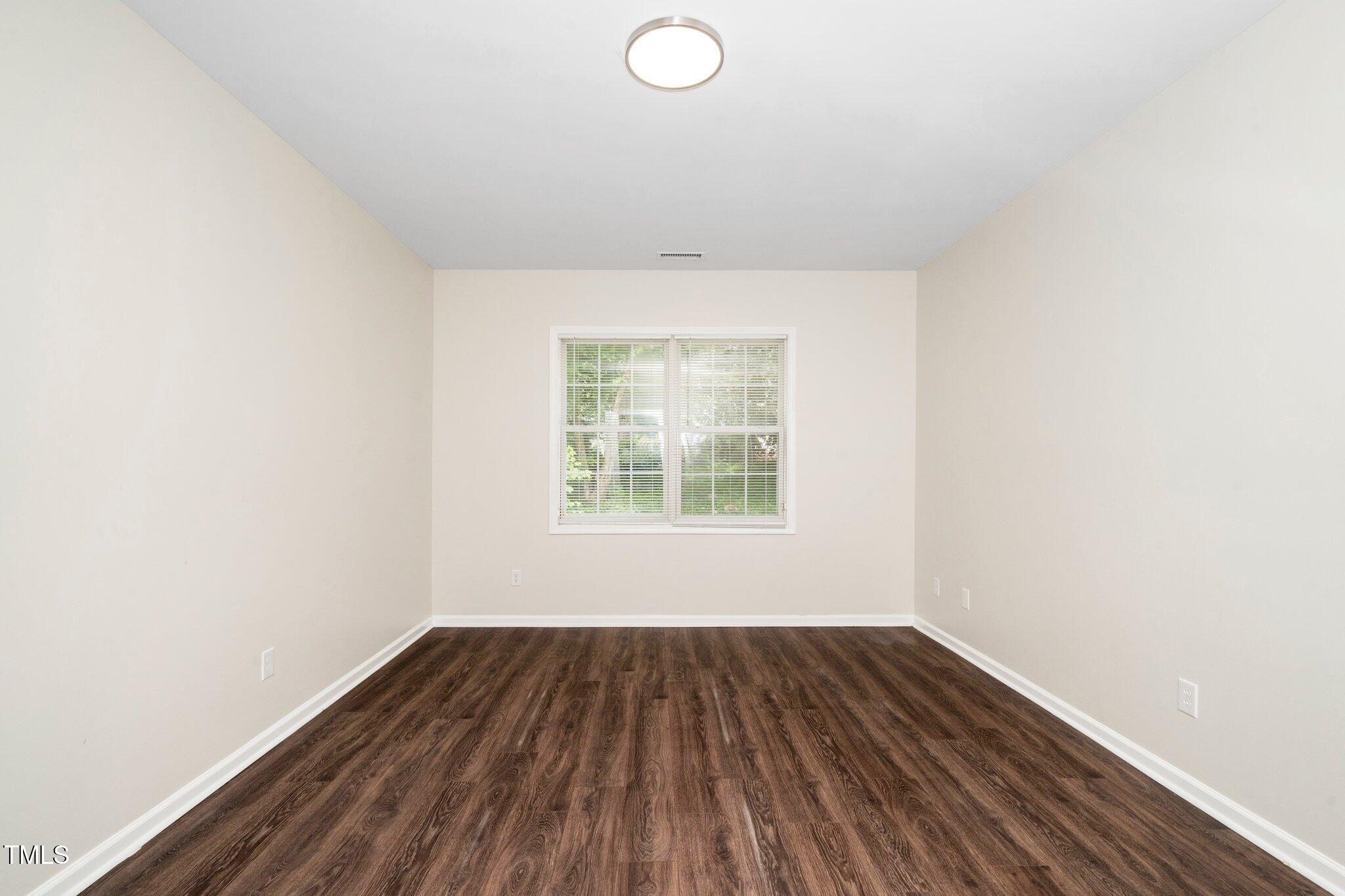 248 Inkster Cove Raleigh, NC 27603 - Photo 18 of 32 an empty room with wooden floor and windows