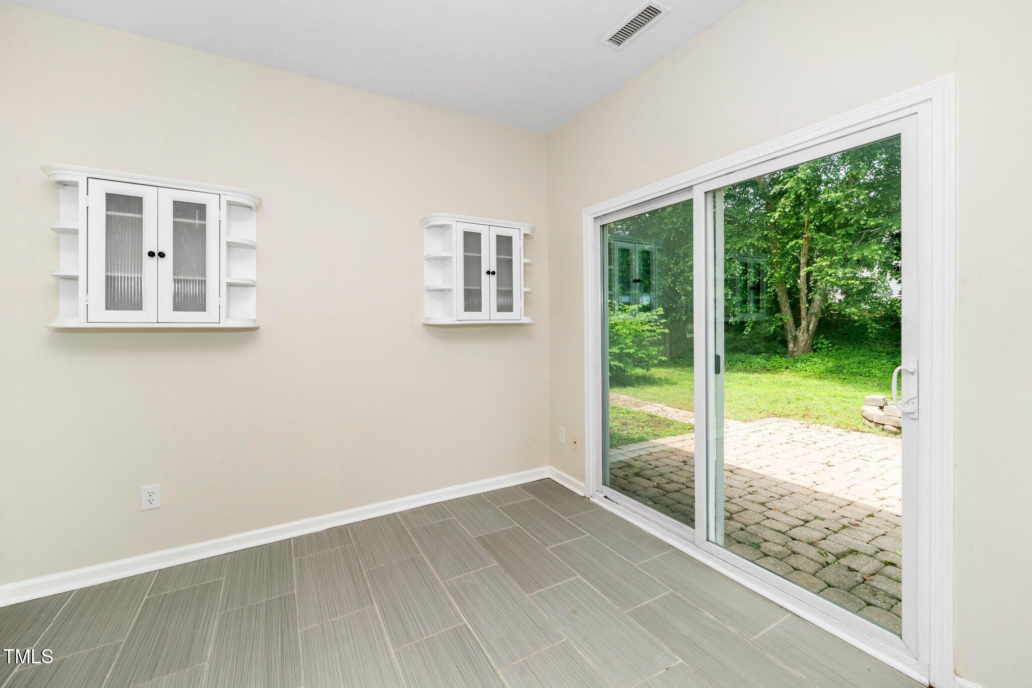 248 Inkster Cove Raleigh, NC 27603 - Photo 20 of 32 a view of an empty room with wooden floor and a floor to ceiling window