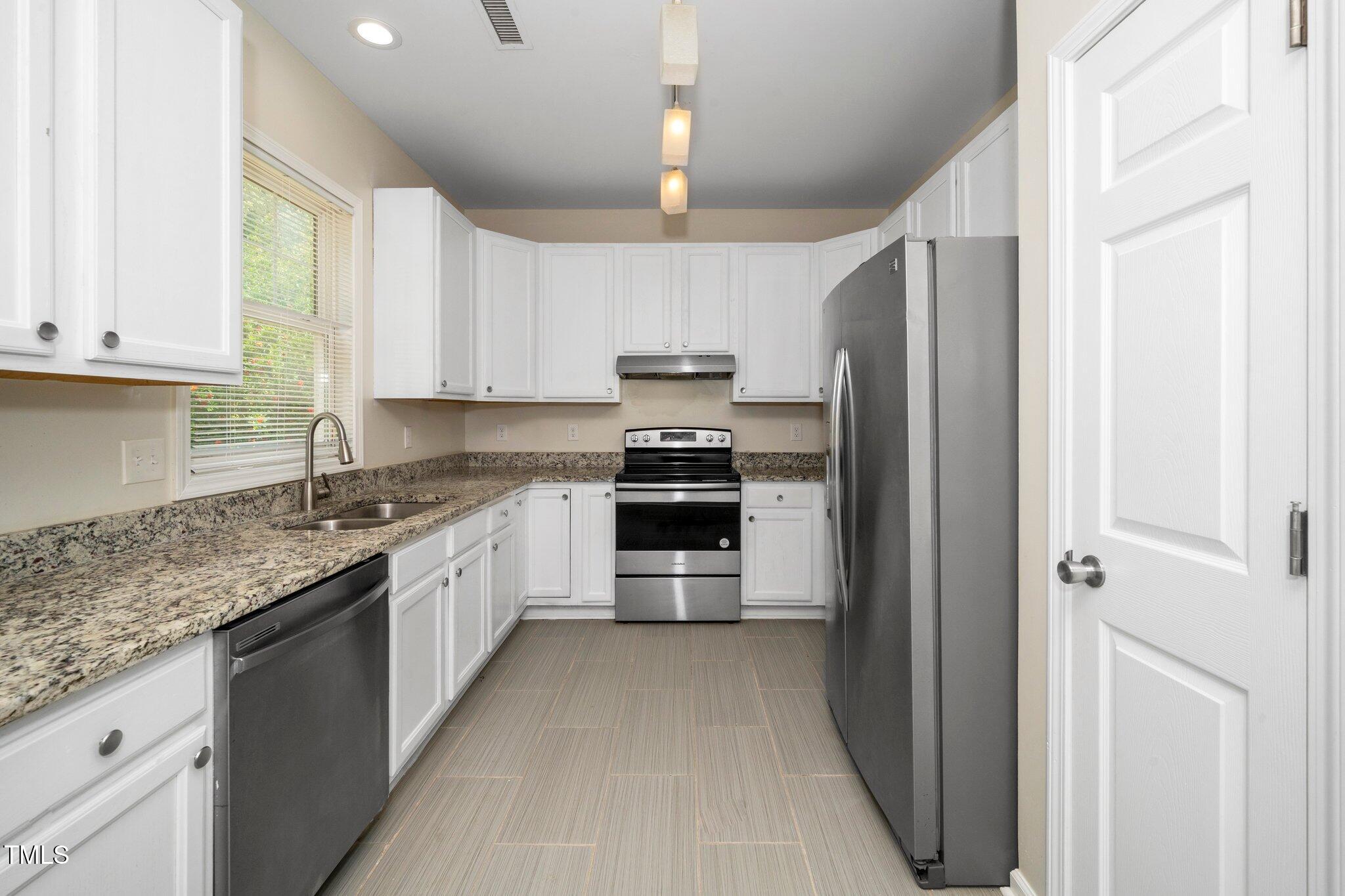 248 Inkster Cove Raleigh, NC 27603 - Photo 22 of 32 a kitchen with granite countertop a refrigerator oven a sink and dishwasher
