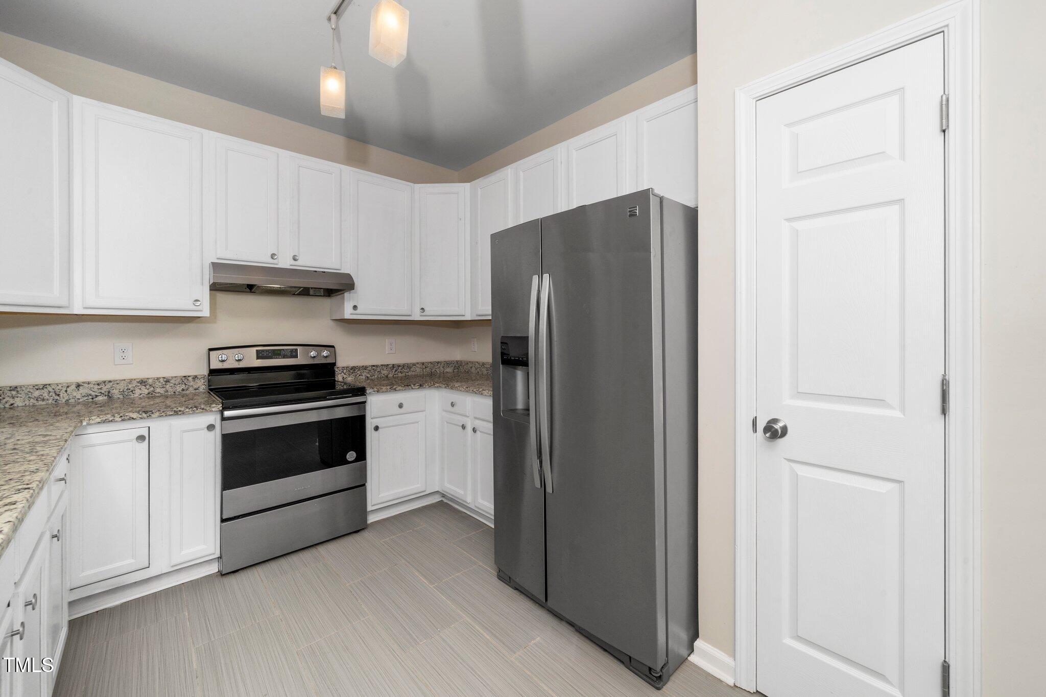 248 Inkster Cove Raleigh, NC 27603 - Photo 23 of 32 a kitchen with a refrigerator stove and white cabinets