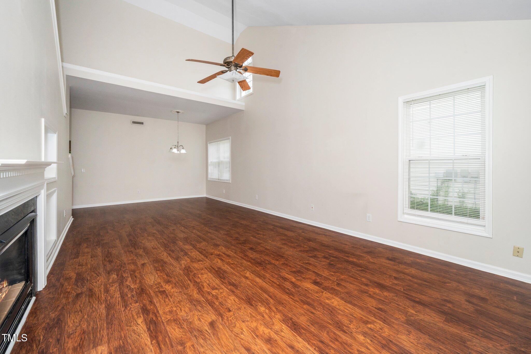 248 Inkster Cove Raleigh, NC 27603 - Photo 6 of 32 an empty room with wooden floor fan and windows