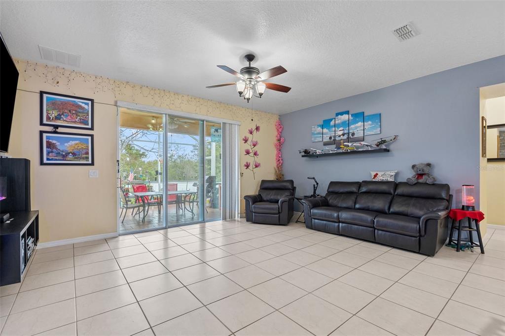 3409 Brant Street St. Cloud, FL 34772 - Photo 15 of 36 a living room with furniture a flat screen tv and a window
