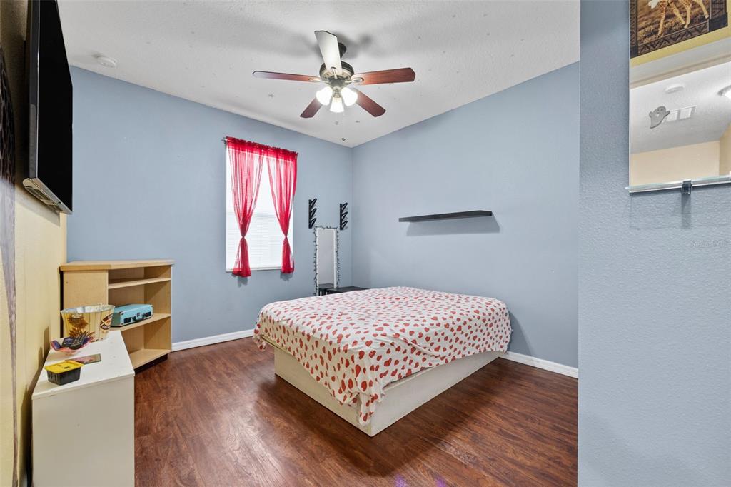 3409 Brant Street St. Cloud, FL 34772 - Photo 19 of 36 a bedroom with a bed window and a flat screen tv