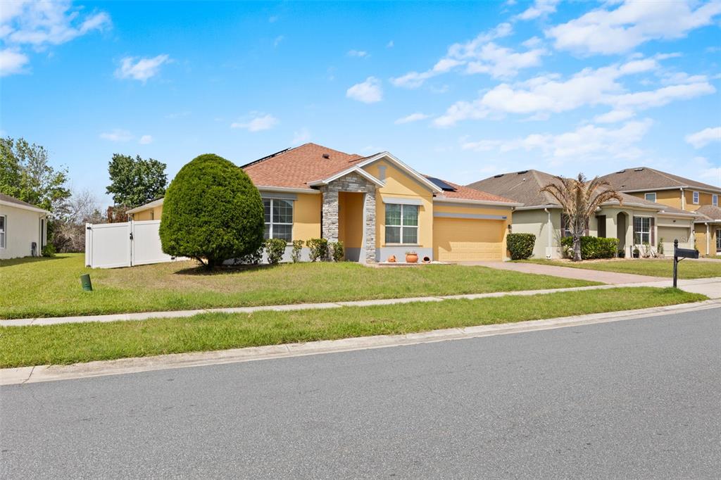 3409 Brant Street St. Cloud, FL 34772 - Photo 2 of 36 a view of a white house with a big yard and potted plants