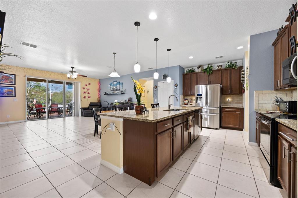 3409 Brant Street St. Cloud, FL 34772 - Photo 10 of 36 a large kitchen with stainless steel appliances lots of counter space and windows