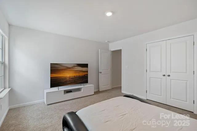 a living room with a flat screen tv furniture and a window