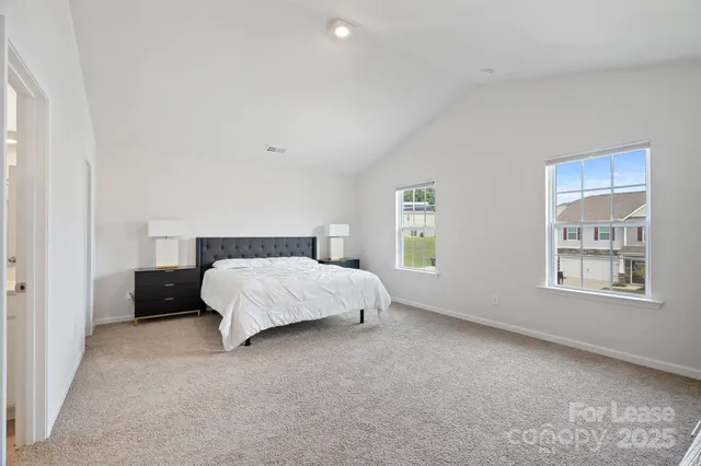 a bed sitting in a bedroom next to a window
