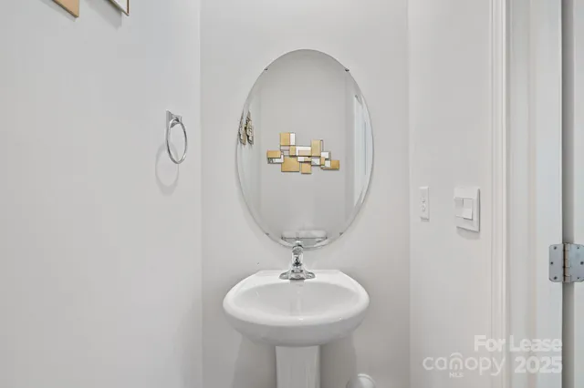 a bathroom with a sink a mirror and a light fixture