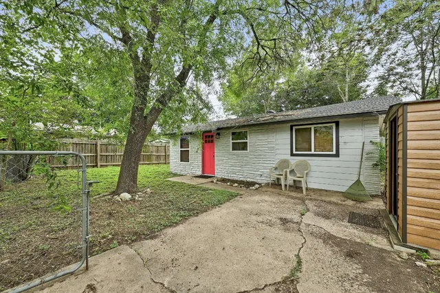 a backyard of a house with table and chairs