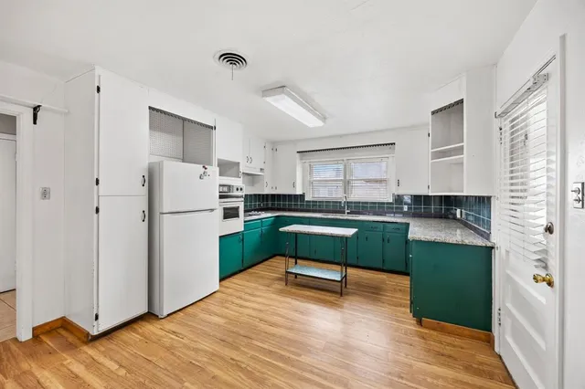 a kitchen with a refrigerator and a wooden cabinets