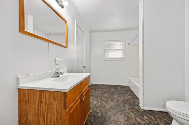 a bathroom with a sink a toilet and mirror