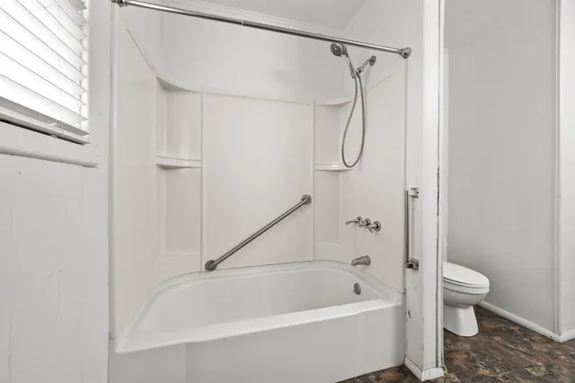 a bathroom with a bath tub with a shower