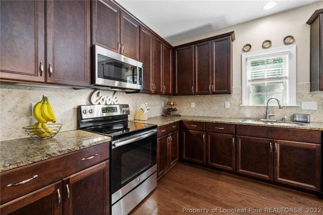 228 Culpepper Road Cameron, NC 28326 - Photo 15 of 36 a kitchen with granite countertop wooden cabinets stainless steel appliances and a window