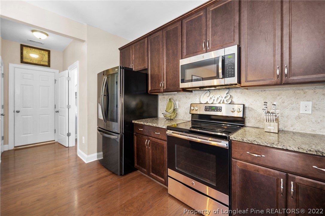 228 Culpepper Road Cameron, NC 28326 - Photo 17 of 36 a kitchen with granite countertop wooden cabinets and stainless steel appliances