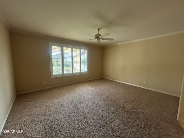 en empty room with windows and chandelier fan